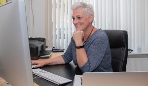 Helen van Rijn leunt op hand achter Imac HelenHelpt Eindhoven
