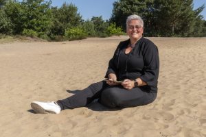 Helen van Rijn zittend in zand